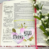 Bible journaling page over Proverbs 31 with 'she is strong' and pink heart accents reading 'tomorrow needs you.'