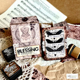 Distressed tags stamped with the butterfly panel and "find the BLESSING in everything," layered with small word strips over sheet music.