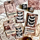 Several tags and cards stamped with the butterfly panel and sentiment in black on distressed pink and cream papers, with Distress ink pads beside them.