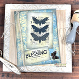 Card with the butterfly panel stamped in black on sheet music, layered over pale blue marbled paper and white embossed card, sentiment "find the BLESSING in everything."
