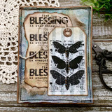 Aged card with the butterfly panel stamped in black on a tag over torn book paper and blue washed edges, sentiment "find the BLESSING in everything" repeated down the background.