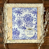 Card with the snowflake in blue tone-on-tone inside an ornate gold frame, 'warm wishes.'