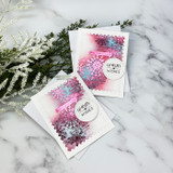 Trio of small pink snowflake cards with 'warm wishes' circles and greenery.