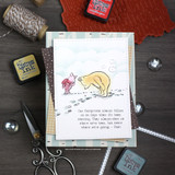 Card of Pooh and Piglet on a cloudy blue winter scene, matted and set among distress inks and twine.