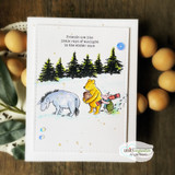 Pooh, Eeyore and Piglet in a snowy scene with pine trees, same friendship sentiment, on white.