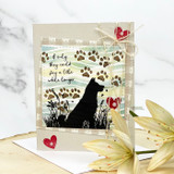 Card with a black dog silhouette among grasses and hearts and a sympathy sentiment, with a lily