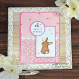 Pink card with a seated bunny and 'oh Hello Spring' framed on a delicate patterned panel.
