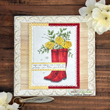 Red rain boots filled with yellow roses on a stitched white panel over red and woodgrain papers with the sentiment 'When life throws you a rainy day, play in the puddles'