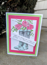 Grey rain boots with pink roses on a white panel framed in green and hot pink, sentiment 'When life throws you a rainy day, play in the puddles'