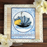 Blue-and-white patterned card with Pooh asleep in a navy umbrella inside a stitched frame.