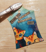 Ink-blended blue tag with two orange tabbies and 'Thank you for watching the cat while we were away.'