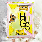 Lemon-print card with three cats peeking around die-cut 'HUGS' letters on pink.