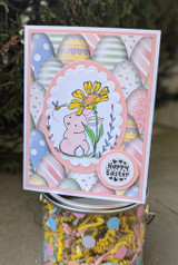 Pastel card with a soft bunny and daisy inside an egg-print oval, 'Happy Easter.'