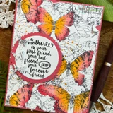 Sample card with the butterfly background colored in coral, orange and gold over white, with a scalloped circle sentiment panel layered in the center.