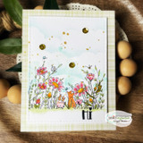 Card with the wildflower meadow and foxes over a soft sky with gold accents.