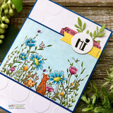 Card with the colored wildflower meadow and foxes over a blue embossed panel with a 'hi' badge.