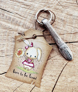 Kraft tag card of the bunny holding a flower with 'born to be loved.'