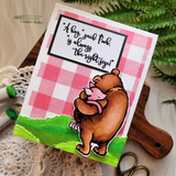 Card with Pooh and Piglet colored on a green hill over pink gingham and the 'hug' sentiment.