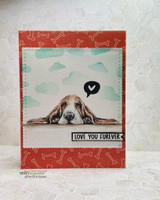 Card on red bone-print paper with the basset hound colored brown and tan under a cloudy sky, a heart speech bubble and the 'love you furever' strip.