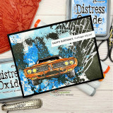 A black framed card with the shatter background stamped over blue and green splattered ink, topped with an orange muscle car and a small sentiment strip.