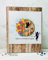 Whimsical card with a fairy door in a tree, tiny fairies and flowers, over 'Hope your birthday is magical.'