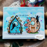 Card with two fairy doors and fairies over a bright sky, with 'Enter with Wonder.'