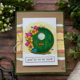 Kraft card with a round fairy door among flowers and 'you're on my mind.'