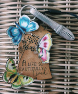 Kraft tag card with blue and green butterflies and 'A life so beautifully lived.'