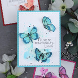 Card with teal-blue butterflies on a pink-and-blue watercolor panel, 'A life so beautifully lived.'