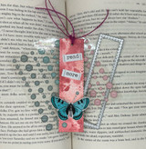 Pink-and-teal bookmark with a butterfly and 'read more' / 'day dreamer' tags.