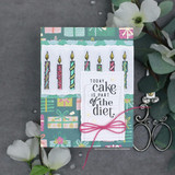 Gift-print card with a pink bow: a row of colored candles above “TODAY cake is part of the diet.”