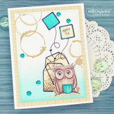 A tea bag beside a little owl holding a mug of tea on a teal card, captioned "Happy tea", with coffee-ring stains and a doily.