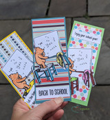 A hand fans three slimline back-to-school cards featuring the teaching bear.