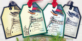 Two kraft tags with the colored snowman tied with ribbon, holiday sentiments, evergreen sprigs