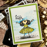 Card with the joyful girl in a yellow dress, arms raised, stamped 'sending hugs,' on a green frame.
