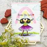 Card of the girl in a magenta dress beneath a pastel rainbow, stamped 'Praise the Lord!'
