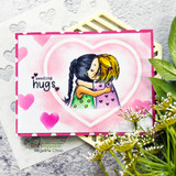 Card with the girls hugging inside a pink heart over hearts paper and 'sending hugs.'