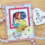 Card with two hugging girls in bold color over blue floral paper with daisies and 'sending hugs.'