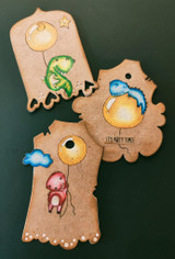 Kraft die-cut tags with dinosaurs in green, blue and red holding balloons, one stamped 'It's party time.'