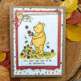 Card with a red patterned border and Pooh holding a leaf, 'It's just like you to be so thoughtful.'