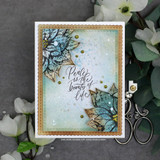 Card with a blue and copper poinsettia over a misty panel and 'Peace is the beauty of life.'