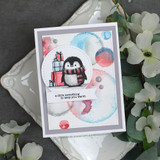 Soft watercolor circles in blue, pink and red behind a penguin with gift boxes, over 'a little something to keep you warm.'