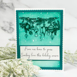 Teal scalloped card with the ornament garland stamped in dark green over a snowy teal panel and 'From our home to yours. Sending love this holiday season'.