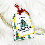 Yellow-trimmed white tag of the colored spruce on holiday paper with red berry sprig