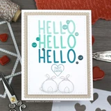 Kraft card with a white panel where the large "Hello" stamp is repeated three times in graduated teal, two small bunnies below with a "SWEET CHEEKS" tag and teal sequins.