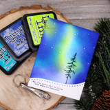 Card with a pine tree against a blue-and-green northern-lights sky, 'You are capable and resilient, dear one.'