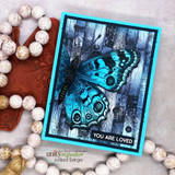 Card with the butterfly inked blue over weathered wood: 'You are loved.'