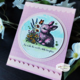 Card with the bunny and wildflowers in a circle on a pink card: 'You make the world a little brighter.'