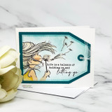 Teal tag card of the girl and drifting seeds with the holding-on-and-letting-go quote.