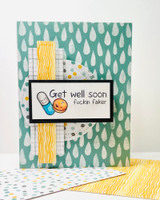 Card with a smiling pill-capsule stamp and an adults-only 'Get well soon' sentiment on a teal raindrop background.